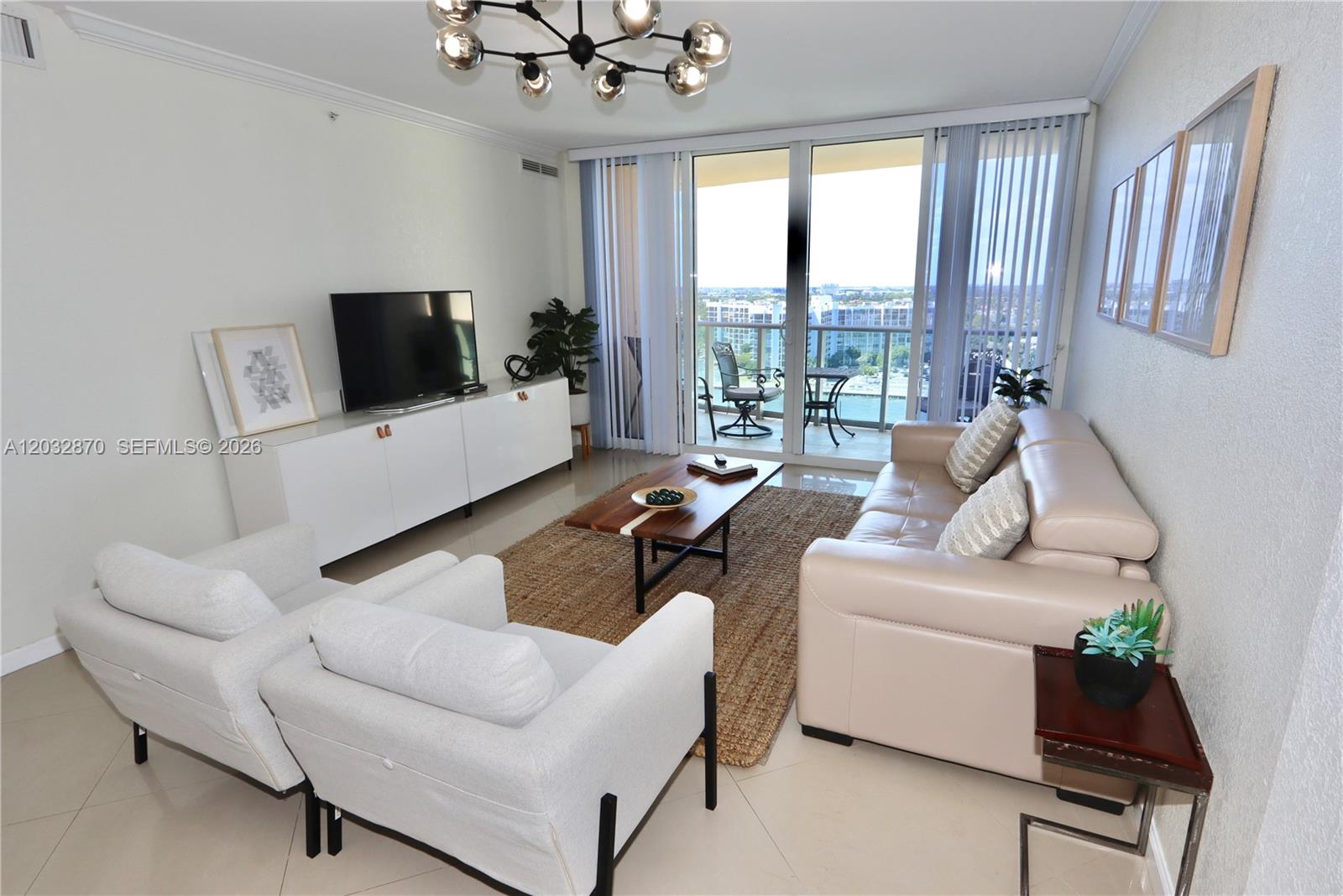 A living room features a beige sofa, two white armchairs, a coffee table, and balcony access — 2501 S Ocean Dr # 1430, Hollywood FL 33019, HOLLYWOOD, FL