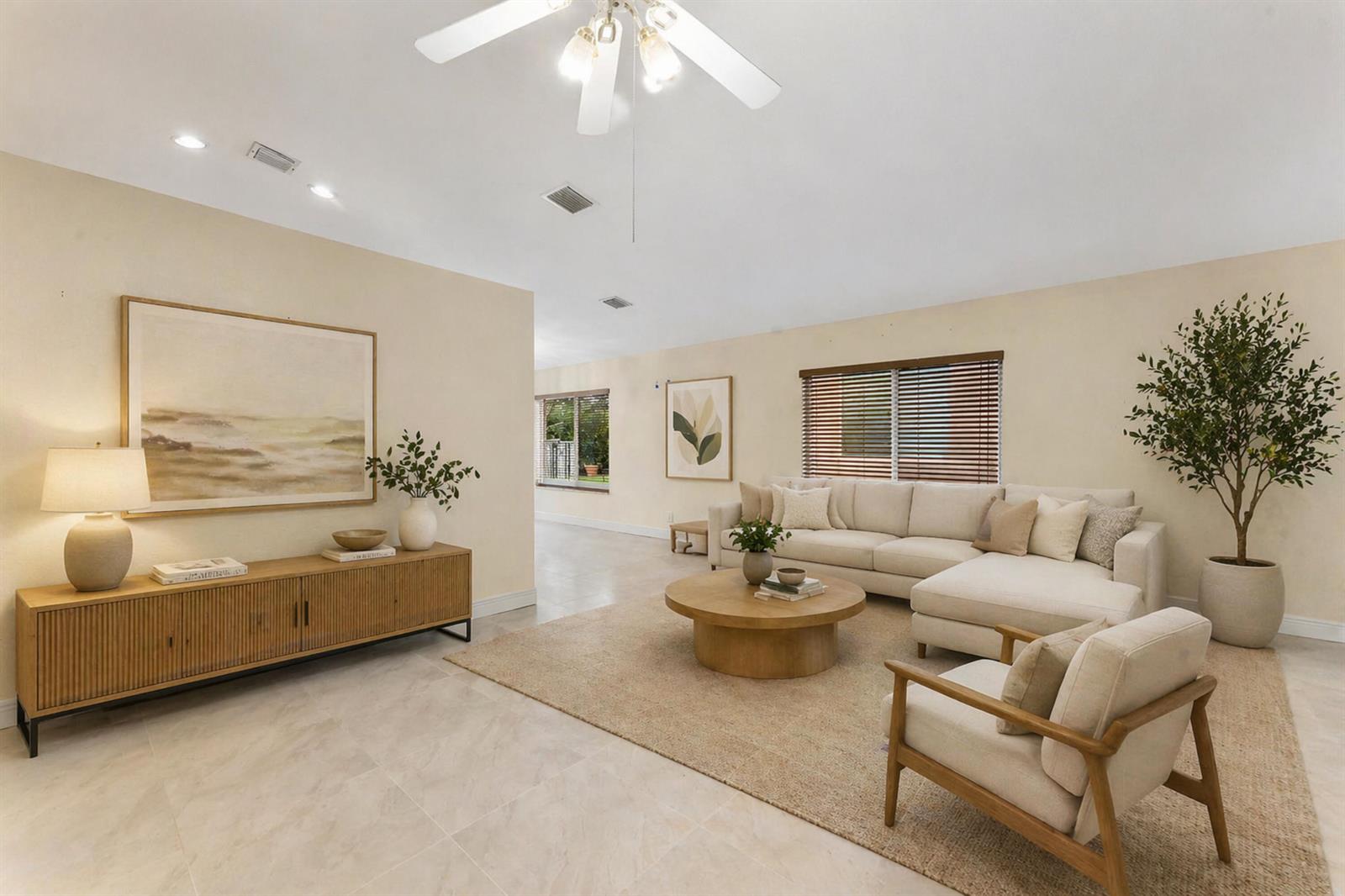 A living room features a beige sectional sofa, a round wooden coffee table, and tile flooring — 1353 Canary Island Drive, Weston FL 33327, WESTON, FL