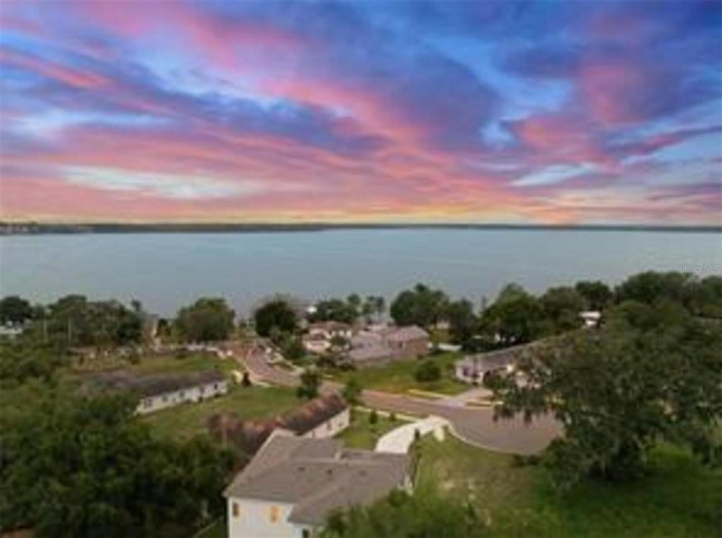 An aerial view of a residential neighborhood situated along a large lake at sunset — 1825 MOORINGS COURT LOT 14, CLERMONT, FL