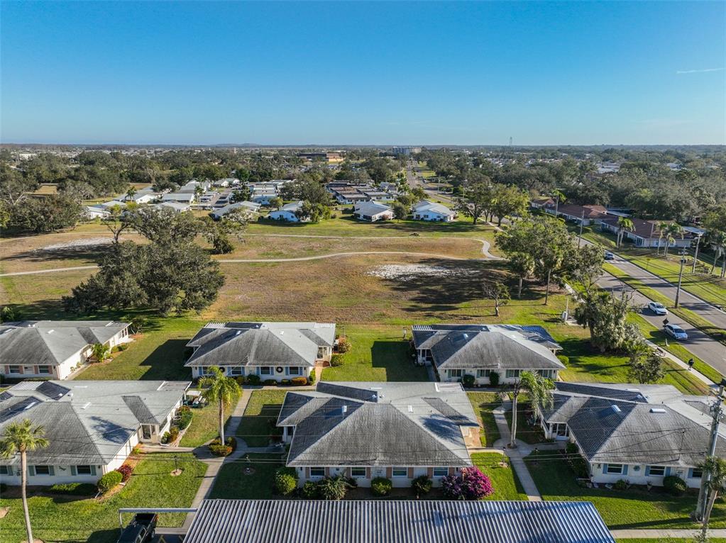 An aerial view shows several single-story residential buildings surrounded by green lawns and trees — 1901 CANTERBURY LANE UNIT 19, SUN CITY CENTER, FL