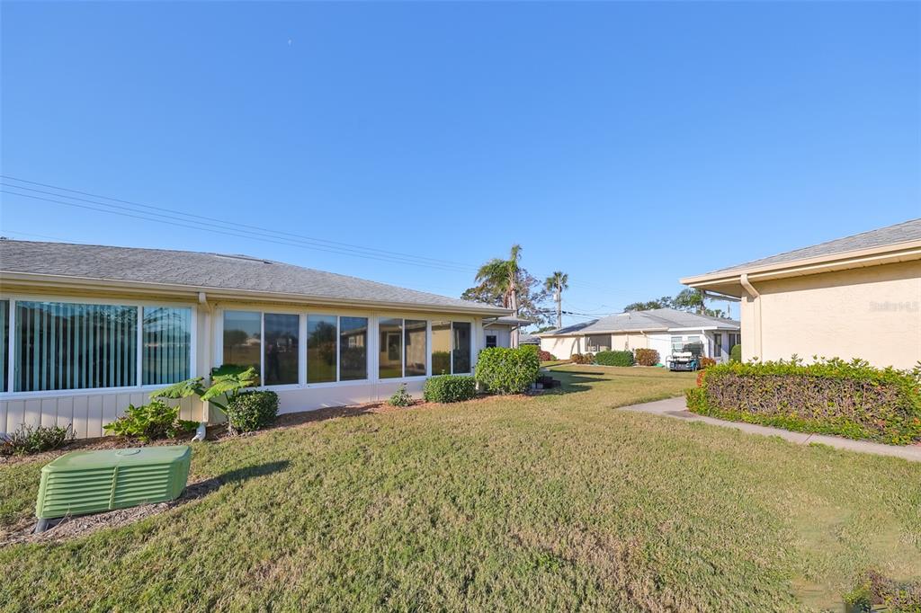 The exterior view shows a house with a sunroom, a grassy yard, and neighboring homes — 1901 CANTERBURY LANE UNIT 19, SUN CITY CENTER, FL