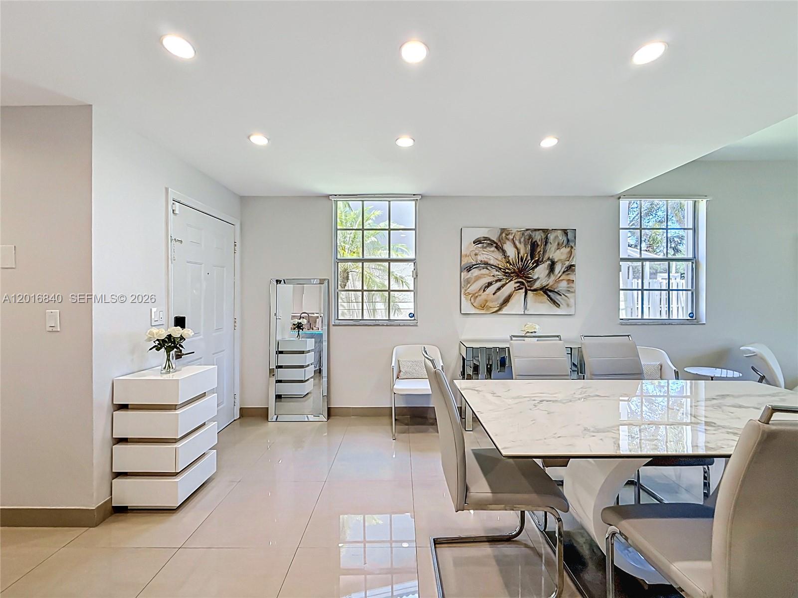 A dining room features a marble-topped table, modern chairs, a mirrored console, and tiled floors — 952 Sevilla Cir, Weston FL 33326, WESTON, FL
