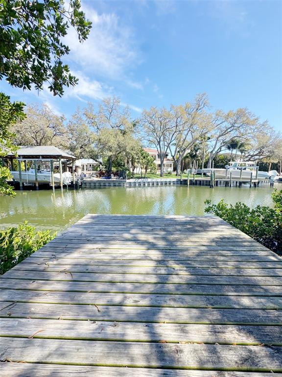 A wooden dock overlooks a canal with boat lifts and houses in the background — 5104 W SAN JOSE STREET, TAMPA, FL
