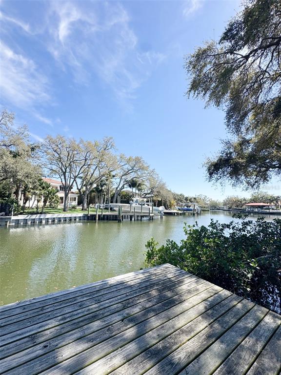 A wooden dock overlooks a canal with boats and waterfront homes under a blue sky — 5104 W SAN JOSE STREET, TAMPA, FL
