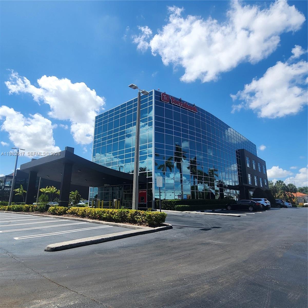 A modern glass-facade office building with a covered entrance and a parking lot — 2500 NW 107th Ave # 400, Doral FL 33172, DORAL, FL