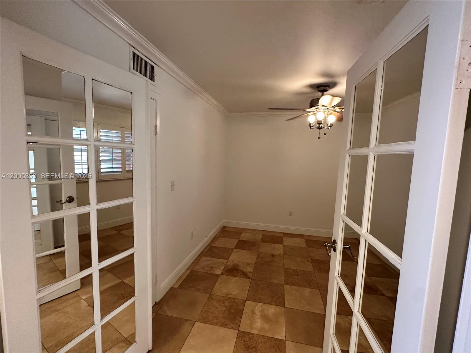 A room with tiled floors, a ceiling fan, and white French doors — 1250 Lincoln Rd # 406, Miami Beach FL 33139, MIAMI BEACH, FL