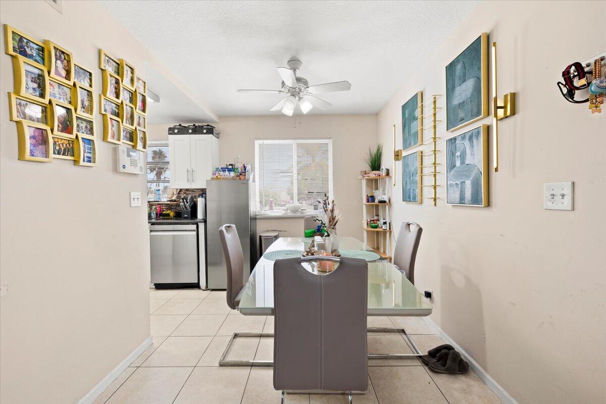 A dining area features a glass table, four gray chairs, and wall-mounted artwork — 1905 Lake Worth Road, FL 33461, FL