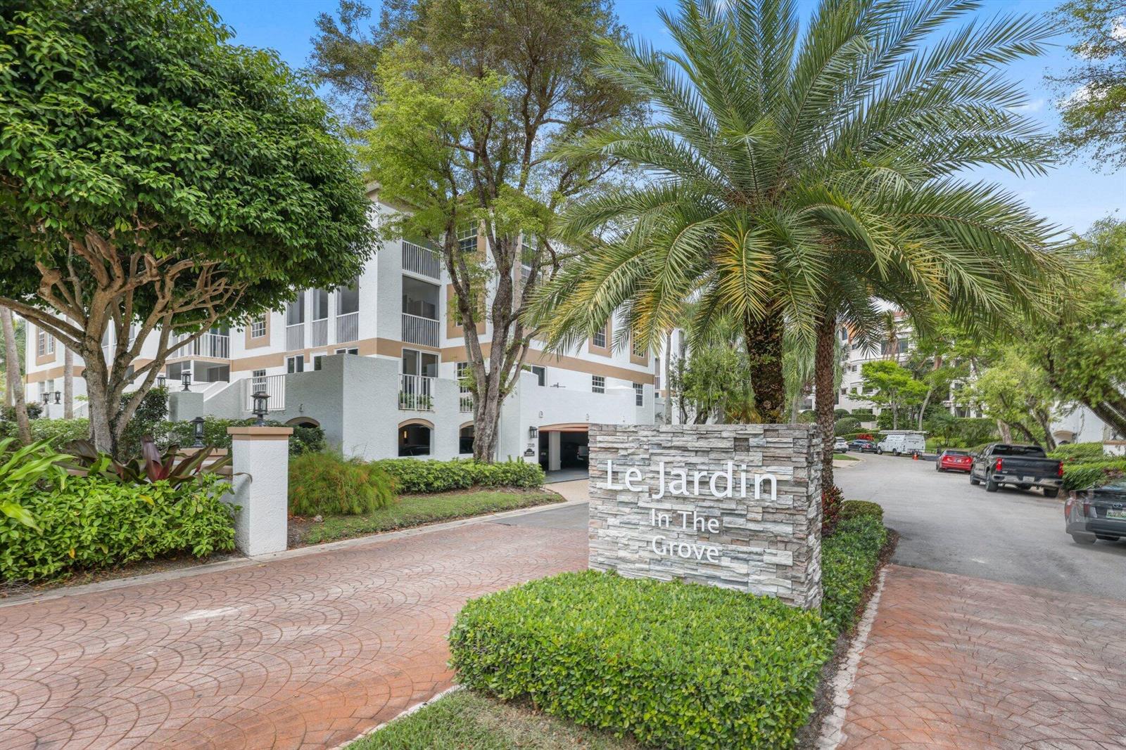 A stone sign for Le Jardin In The Grove stands before a multi-story apartment building — 7370 Orangewood Lane # 302, Boca Raton FL 33433, BOCA RATON, FL