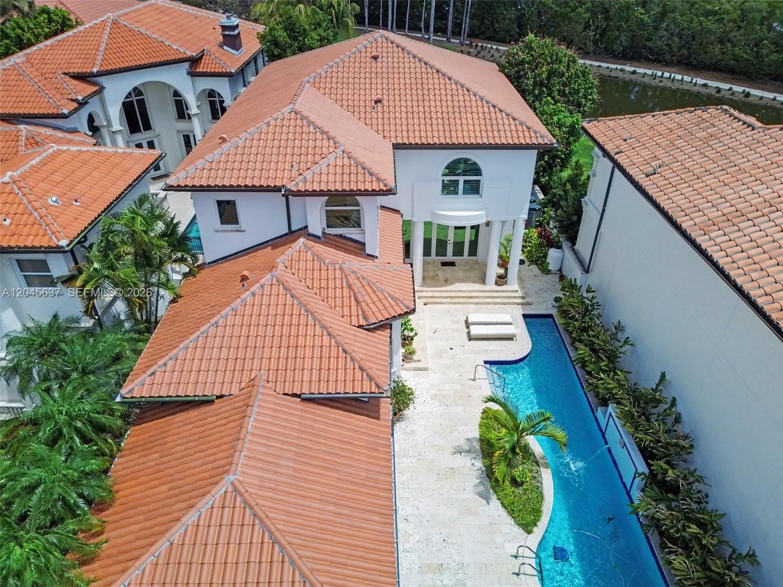 An aerial view shows a house with a terracotta tile roof and a swimming pool — 13689 Deering Bay Dr, Coral Gables FL 33158, CORAL GABLES, FL