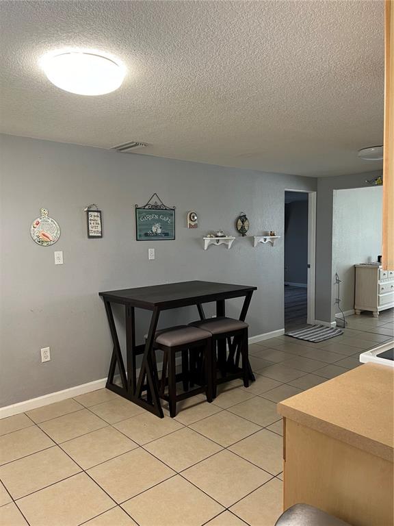 A dining area features a dark wood table with two stools against a gray wall — 705 CRESTVIEW CIRCLE NW, PORT CHARLOTTE, FL