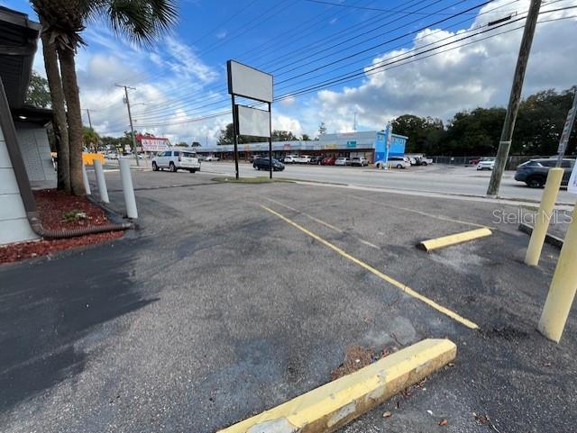 An asphalt parking lot with yellow wheel stops sits in front of a commercial building — 6708 N ARMENIA AVENUE, TAMPA, FL