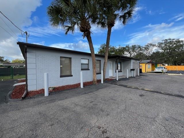 A gray, single-story commercial building with a flat roof and palm trees in front — 6708 N ARMENIA AVENUE, TAMPA, FL