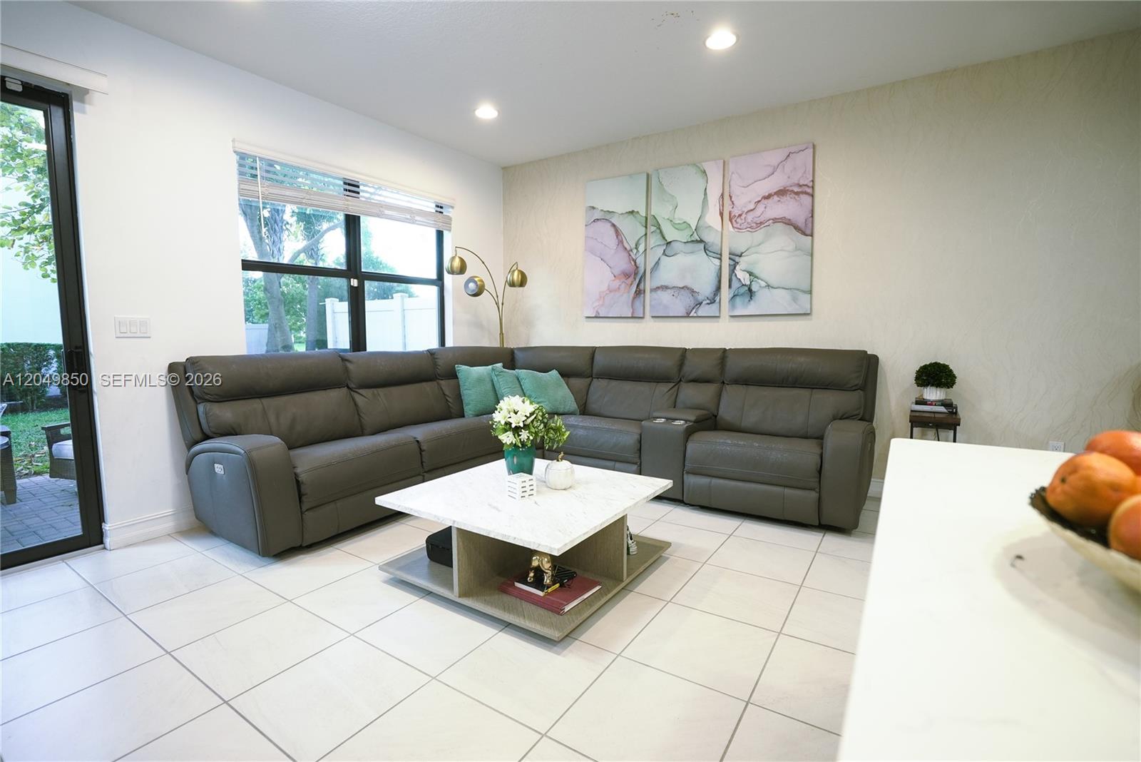 A living room features a large gray sectional sofa, a marble coffee table, and wall art — 10111 Akenside Dr, Boca Raton FL 33428, BOCA RATON, FL