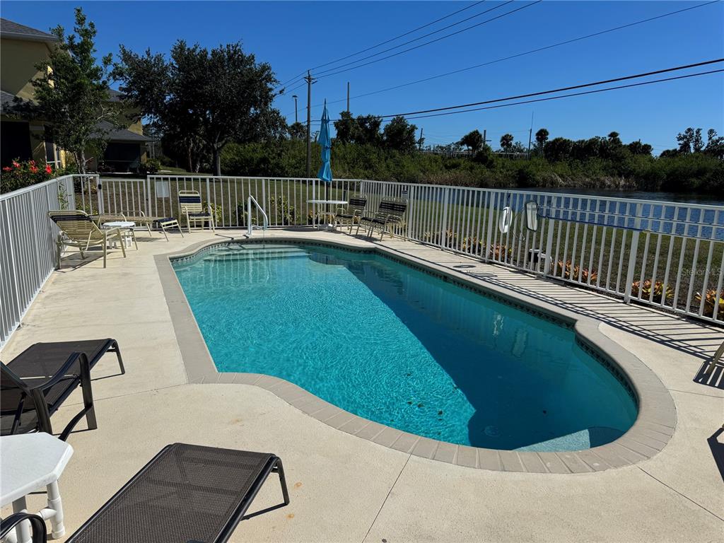 A kitchen with light wood cabinets, laminate countertops, and a view into the living area — 169 BOUNDARY BOULEVARD UNIT 169P, ROTONDA WEST, FL