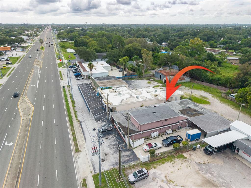 An aerial view shows a commercial building with a flat roof next to a highway — 2865 E BAY DRIVE, LARGO, FL