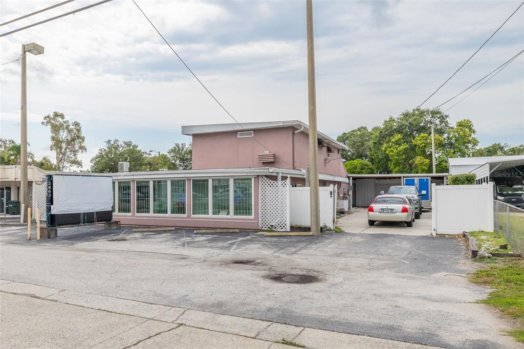 A two-story pink commercial building with a large front window and an adjacent parking lot — 2865 E BAY DRIVE, LARGO, FL