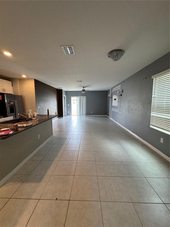 An open-concept living and kitchen area features tile flooring, gray walls, and a breakfast bar — 36569 SMITHFIELD LANE, ZEPHYRHILLS, FL
