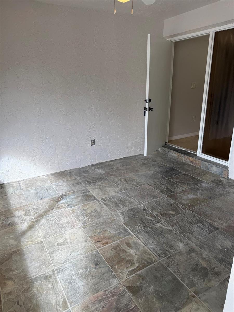 A sunroom with gray slate-style tile flooring and a white door leading indoors — 8601 NW 34th Place # A102, Sunrise FL 33351, SUNRISE, FL