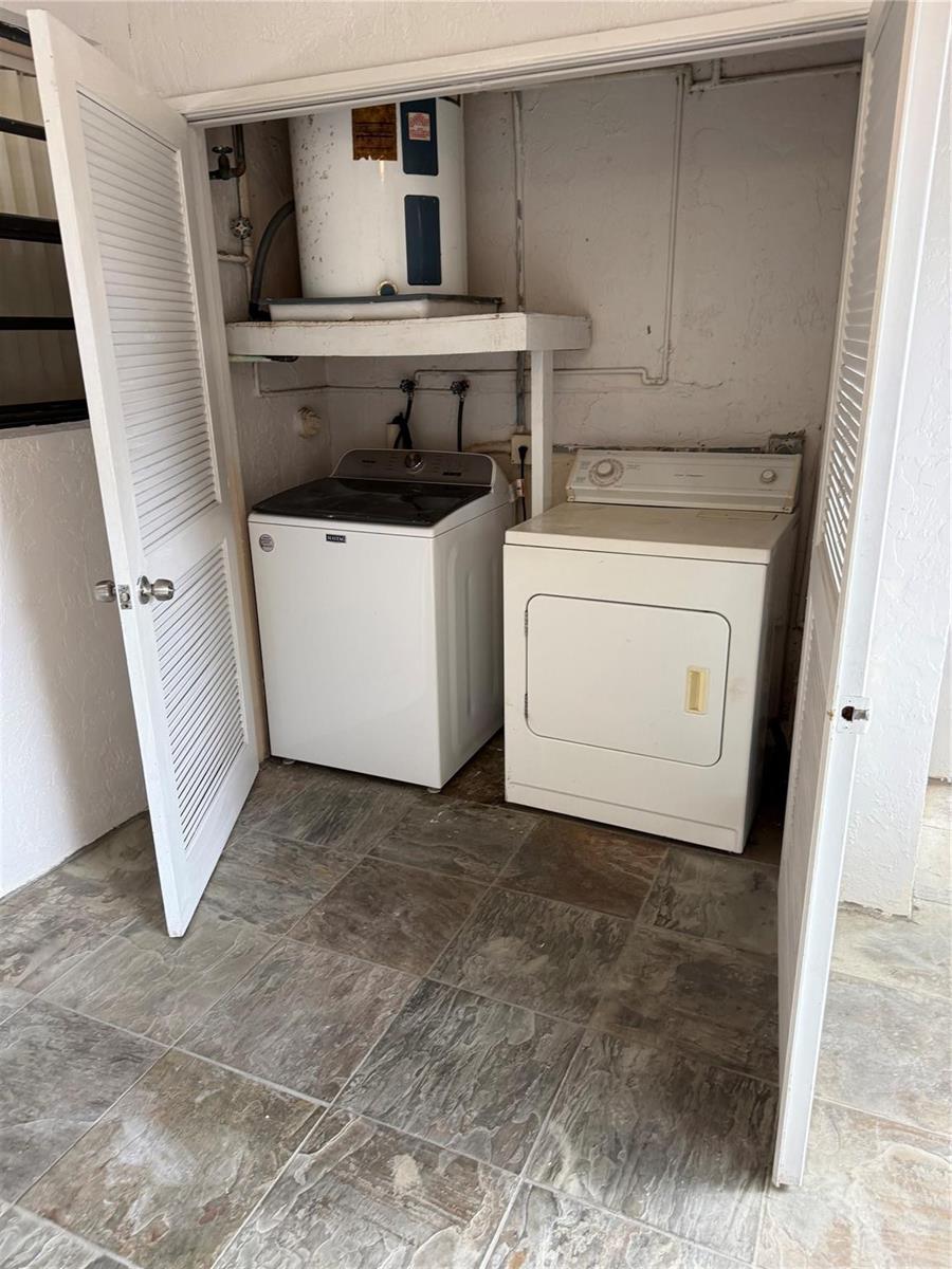 A laundry closet contains a washing machine, a dryer, and a water heater on a shelf — 8601 NW 34th Place # A102, Sunrise FL 33351, SUNRISE, FL
