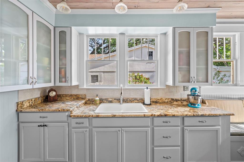 A kitchen features gray cabinets, granite countertops, a white farmhouse sink, and a window view — 212 S COOLIDGE AVENUE, TAMPA, FL