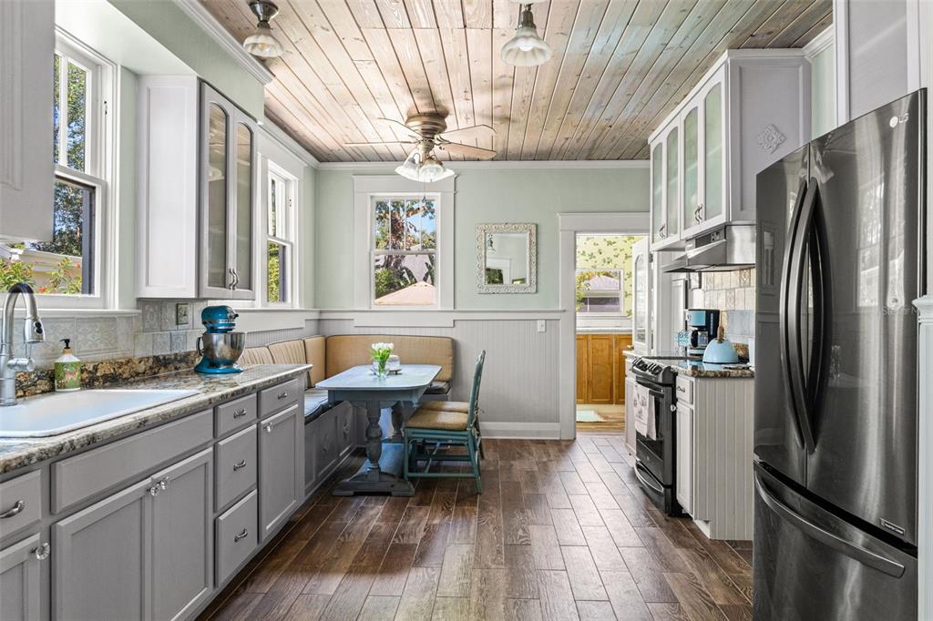A kitchen with gray cabinets, a breakfast nook, wood-plank ceiling, and stainless steel appliances — 212 S COOLIDGE AVENUE, TAMPA, FL