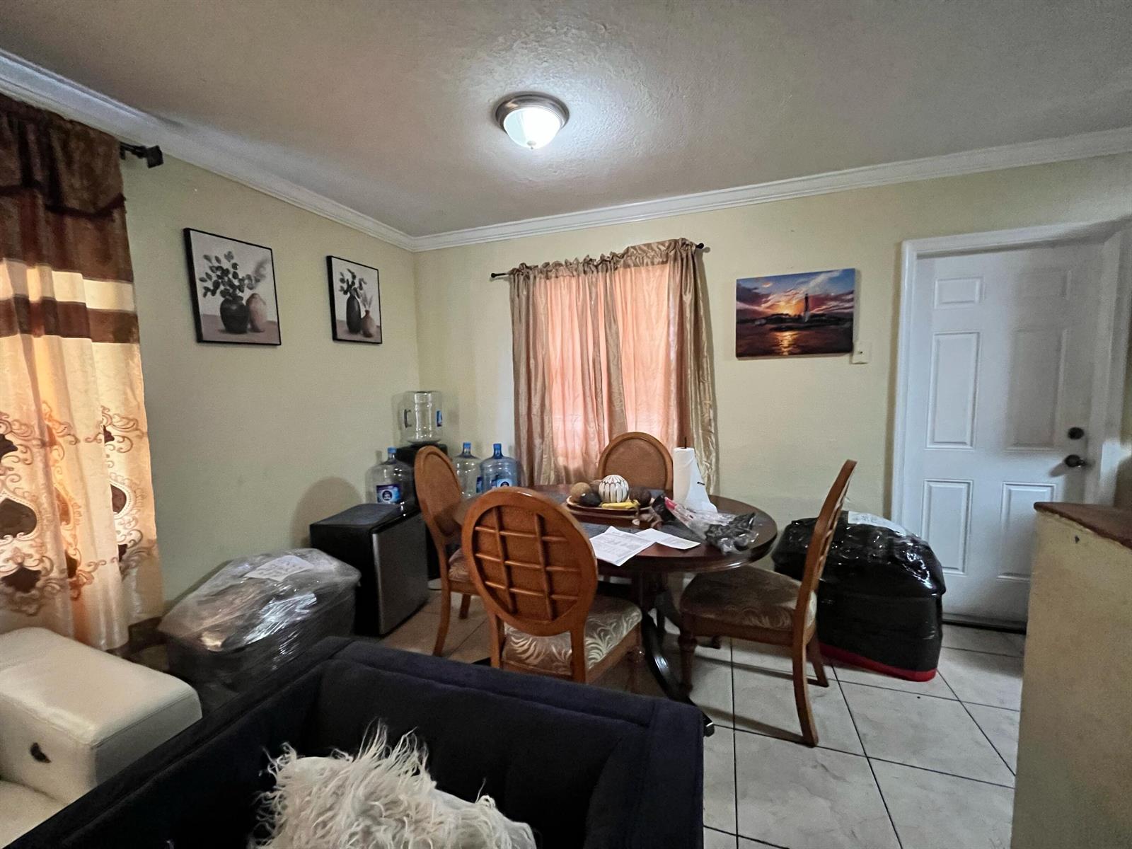 A dining area features a round wooden table, four chairs, and tile flooring — 4730 NE 2nd Avenue NE, Deerfield Beach FL 33064, DEERFIELD BEACH, FL