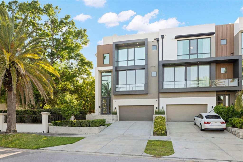 A modern three-story townhouse with a two-car garage and a palm tree in the front — 98 W DAVIS BOULEVARD, TAMPA, FL