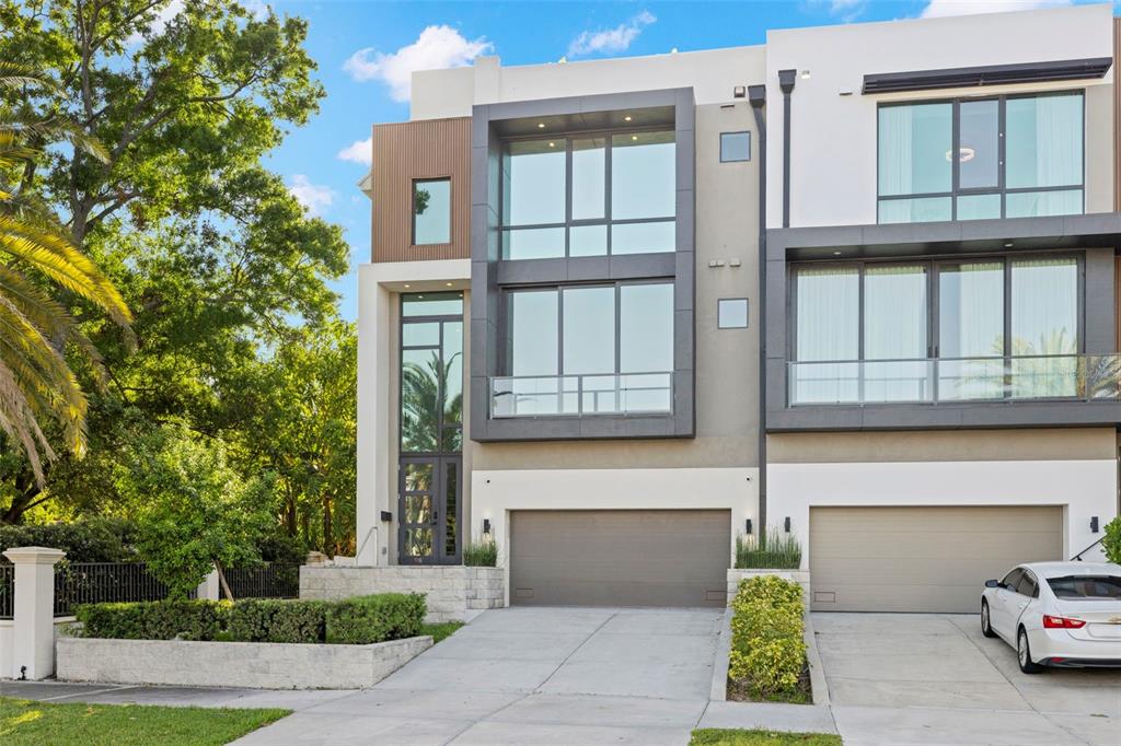 A modern three-story townhouse with a two-car garage and large glass windows — 98 W DAVIS BOULEVARD, TAMPA, FL