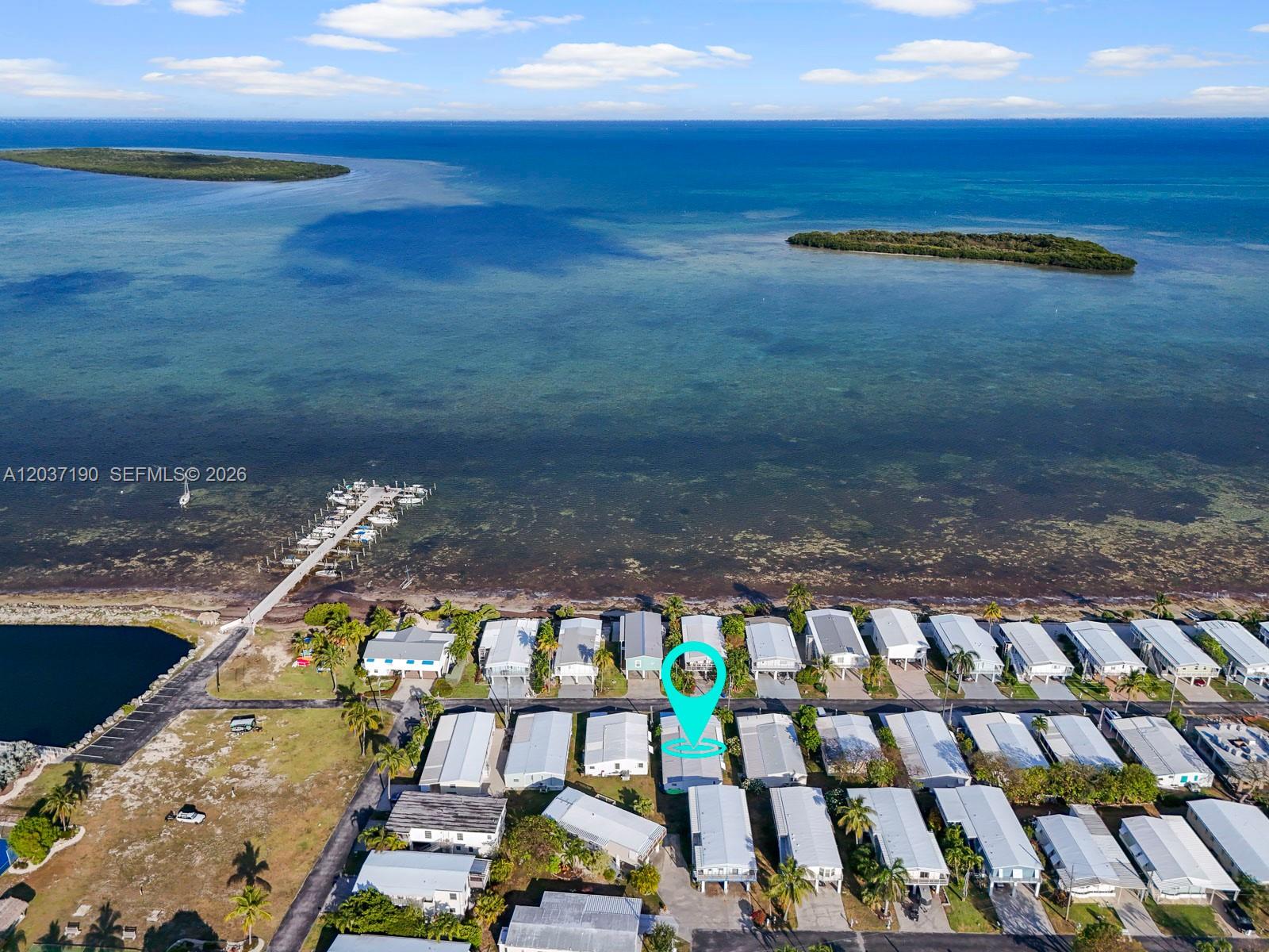An aerial view shows a coastal mobile home community with a pier and islands — 806 S Jade Dr # 806, Key Largo FL 33037, KEY LARGO, FL
