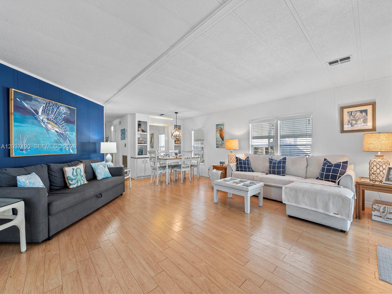 A living room features a blue accent wall, light wood flooring, and two sofas — 806 S Jade Dr # 806, Key Largo FL 33037, KEY LARGO, FL