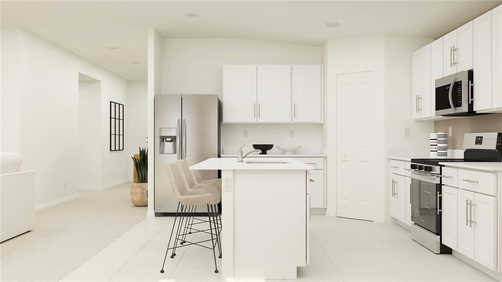 A modern kitchen features white cabinetry, stainless steel appliances, and a central island with seating — 2835 PIONEER TRAIL, EAGLE LAKE, FL