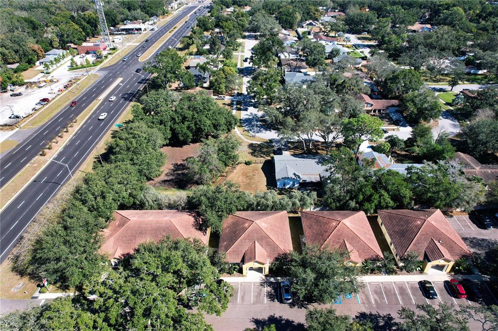 An aerial view shows a row of four attached residential units with tiled roofs — 6957 E FOWLER AVENUE, TAMPA, FL