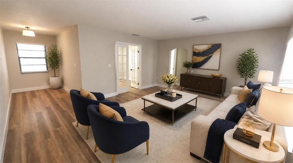 A living room features navy armchairs, a beige sofa, a coffee table, and wood flooring — 2801 NARCISSUS DRIVE, HOLIDAY, FL