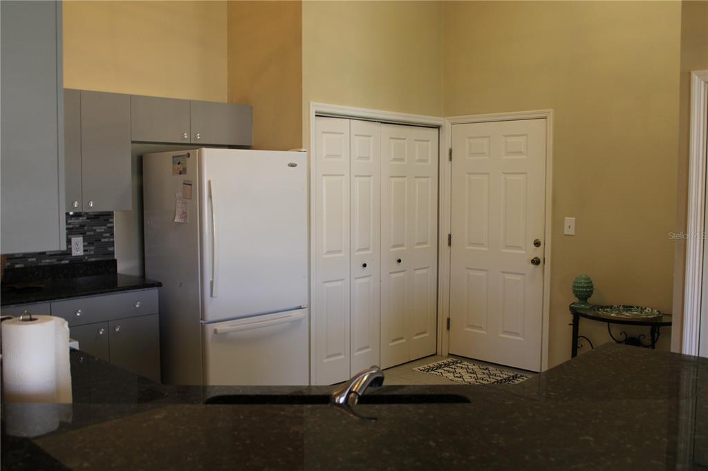 A kitchen features gray cabinets, a white refrigerator, dark countertops, and a white door — 3115 LIVE OAK LANE UNIT 30, PALMETTO, FL