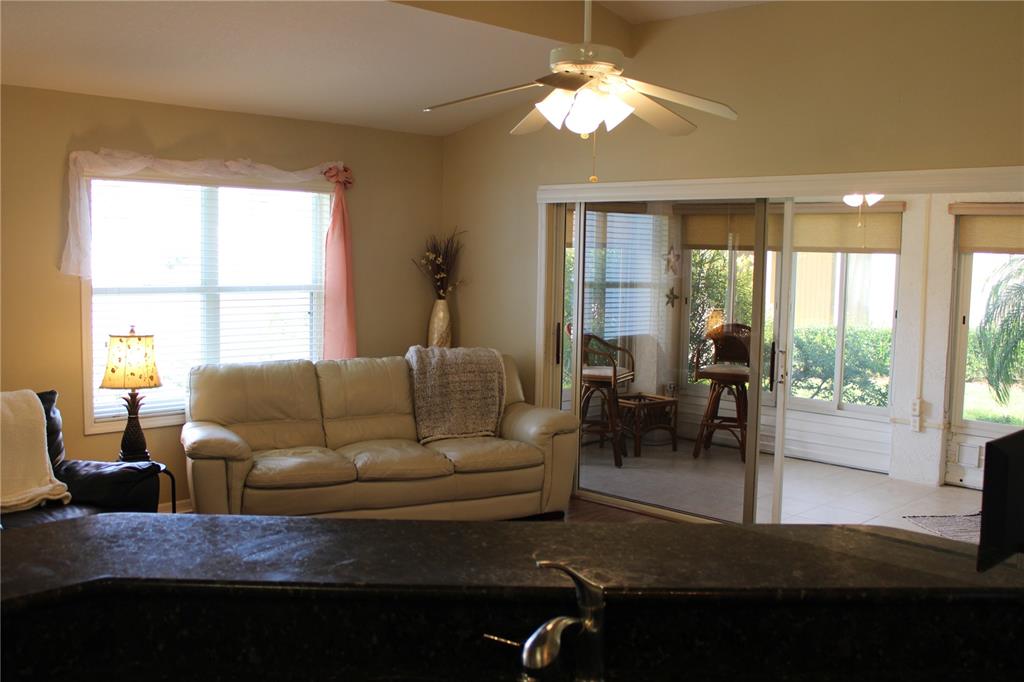 A living room with a beige sofa, ceiling fan, and sliding glass doors to a patio — 3115 LIVE OAK LANE UNIT 30, PALMETTO, FL