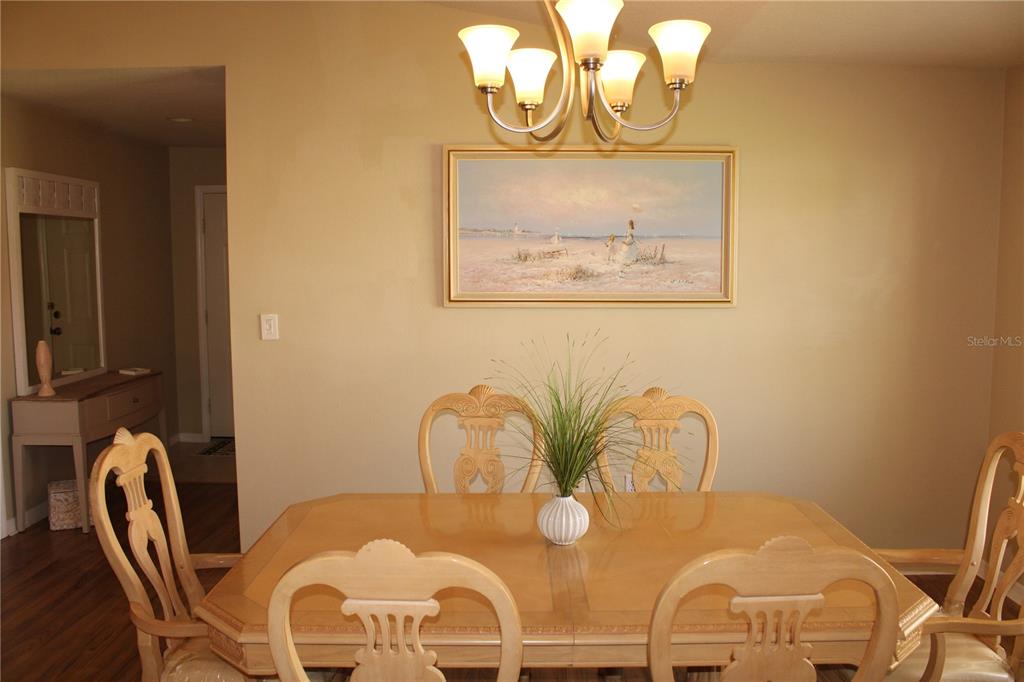 A dining room features a wooden table, six chairs, a chandelier, and a framed painting — 3115 LIVE OAK LANE UNIT 30, PALMETTO, FL