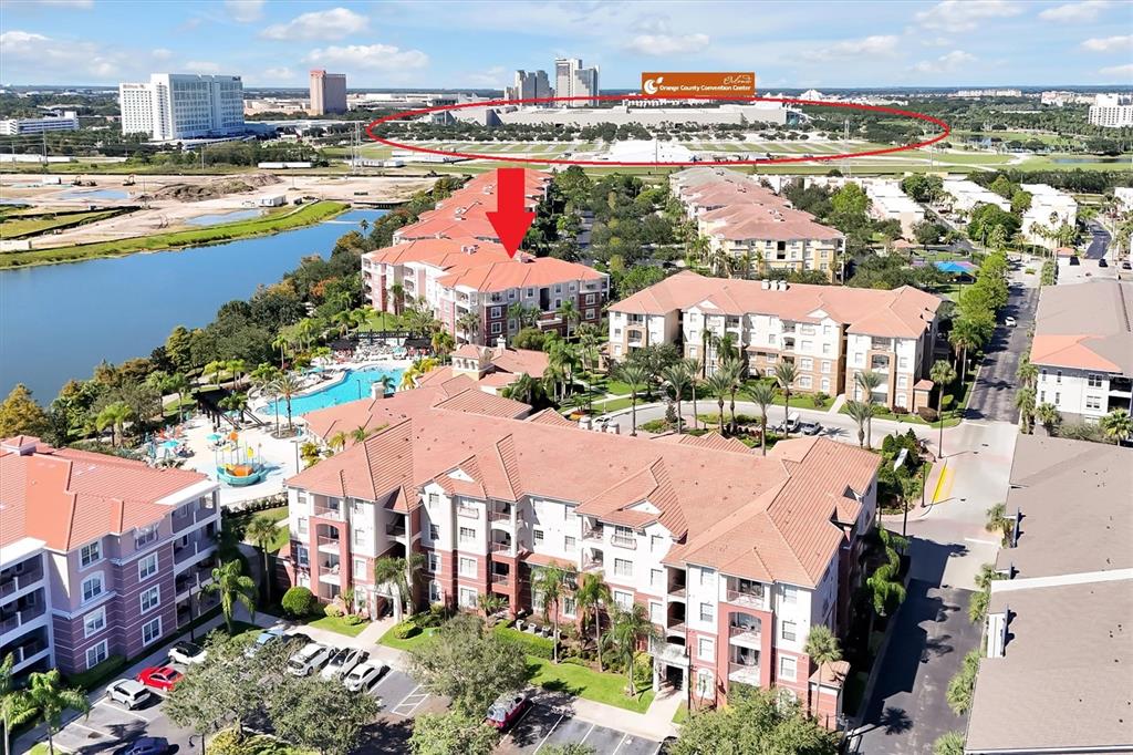 Aerial view of a multi-story apartment complex with a pool near a convention center — 5012 SHOREWAY LOOP UNIT 20507, ORLANDO, FL