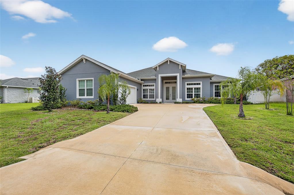 A single-story gray house with a concrete driveway and a front-facing garage — 46 FURNESS PLACE, PALM COAST, FL
