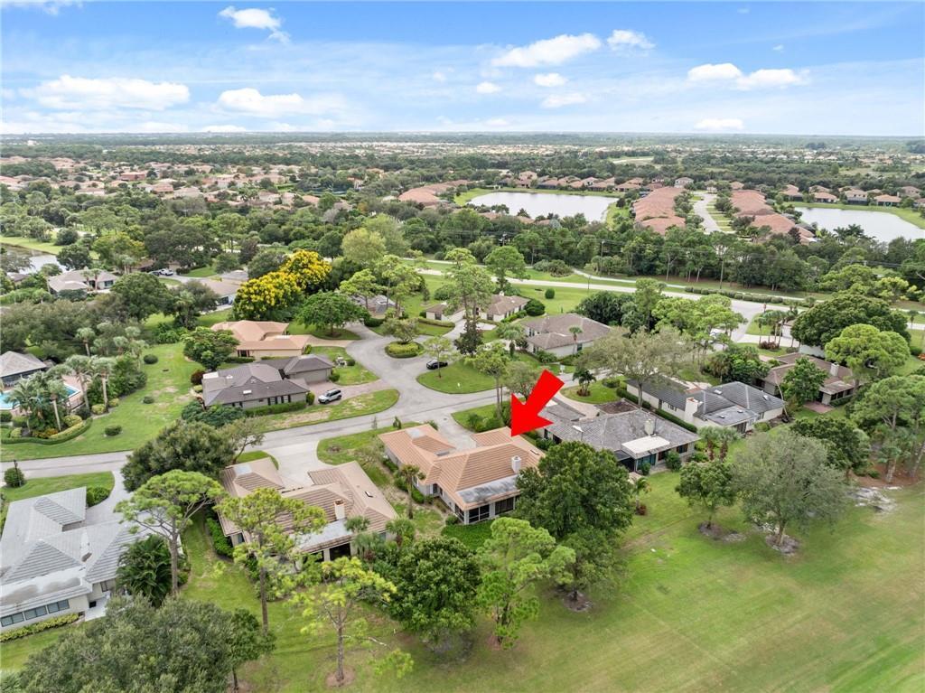 An aerial view shows a single-story house with a tiled roof and a screened-in pool — 110 Prestwick Circle, Vero Beach FL 32967, VERO BEACH, FL