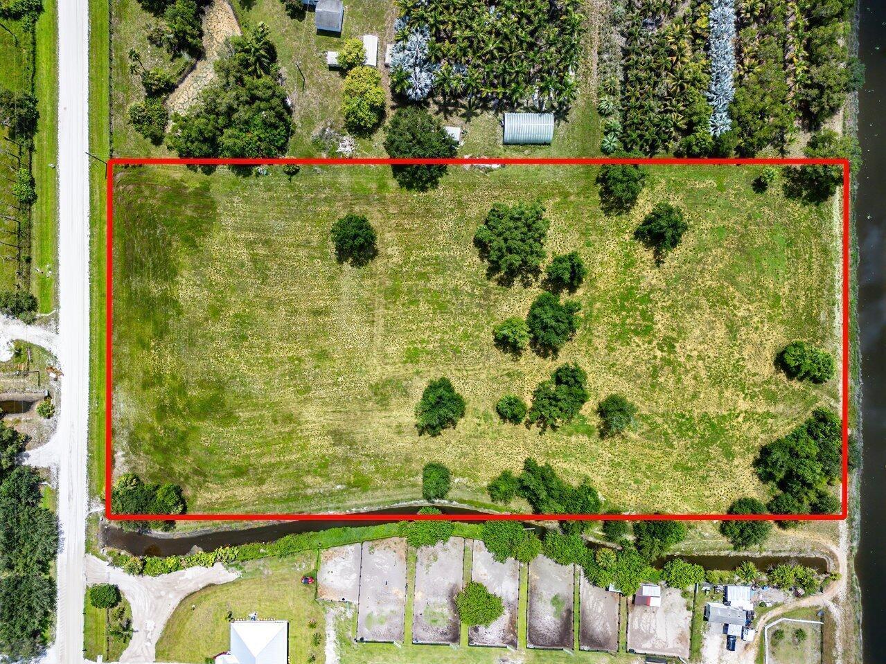 An aerial view shows a rectangular, grassy vacant lot outlined in red next to a road — 16526 Hollow Tree Lane, Wellington FL 33470, WELLINGTON, FL
