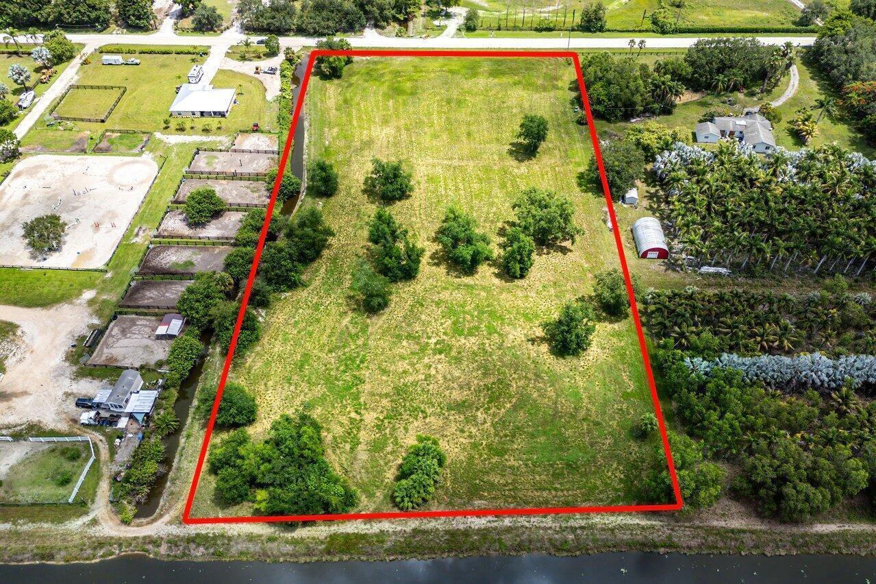 An aerial view shows a rectangular, grassy vacant lot outlined in red with scattered trees — 16526 Hollow Tree Lane, Wellington FL 33470, WELLINGTON, FL