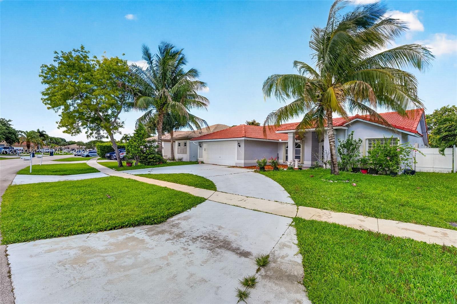 A single-story house with a red tile roof, a concrete driveway, and palm trees — 3462 Harness Cir, Wellington FL 33449, WELLINGTON, FL