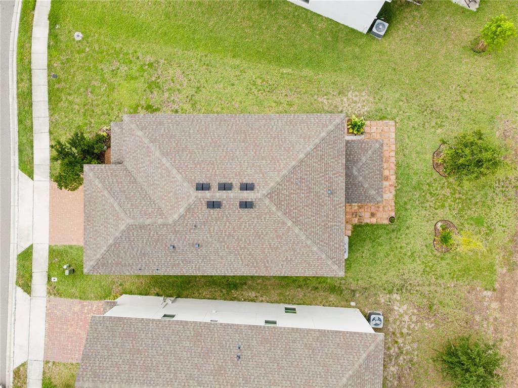 An aerial view shows the shingled roof of a house with a small patio — 779 SCRUB OAK HAMMOCK ROAD, DAVENPORT, FL