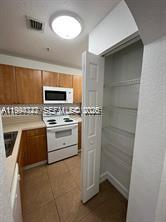 A kitchen features wood cabinets, white appliances, a pantry, and tile flooring — 7995 NW 8th St # 115, Miami FL 33126, MIAMI, FL