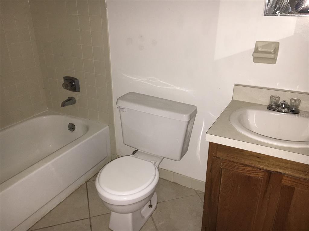 A bathroom features a white toilet, a vanity with a sink, and a tiled bathtub — 6735 SW 45TH AVENUE, GAINESVILLE, FL