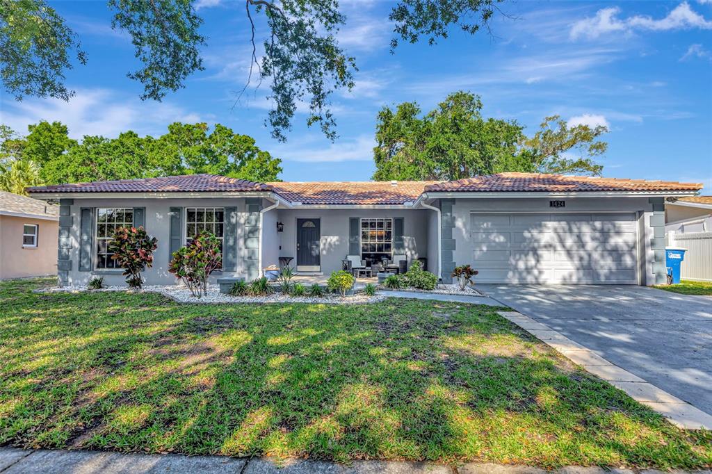 A single-story house with a gray exterior, a tiled roof, and a two-car garage — 1424 STEWART BOULEVARD, CLEARWATER, FL