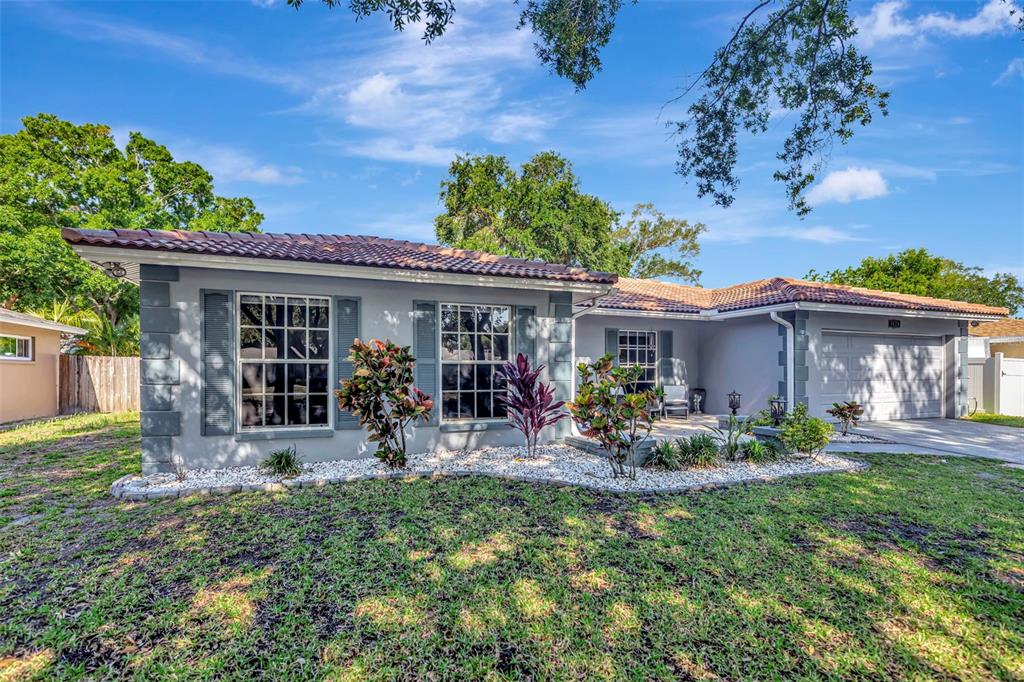 A single-story house with a gray exterior, a tiled roof, and a front-facing garage — 1424 STEWART BOULEVARD, CLEARWATER, FL