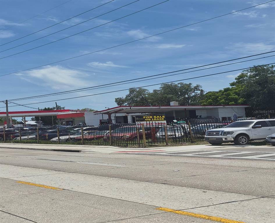 A commercial property with a gas station canopy and a fenced lot full of cars — 2000 S ORANGE BLOSSOM TRAIL, ORLANDO, FL