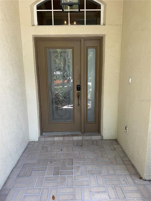 A front entryway features a brown door with decorative glass, a sidelight, and brick pavers — 6506 WATERS EDGE WAY, BRADENTON, FL