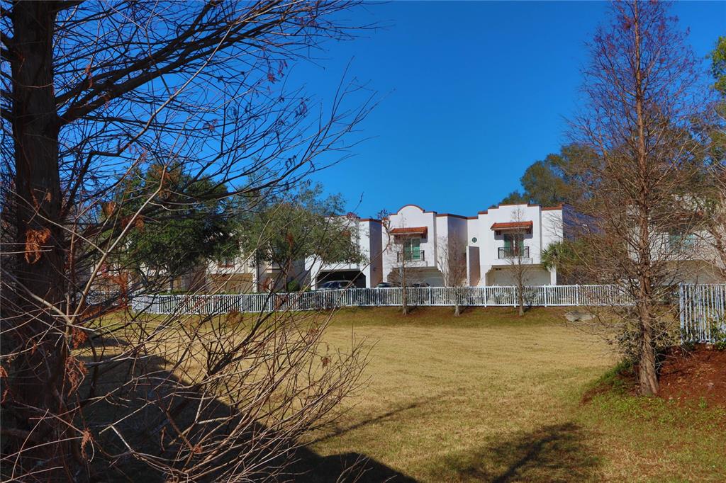 A view of a grassy field in front of a row of white townhouses — 3617 BAY HEIGHTS WAY, TAMPA, FL